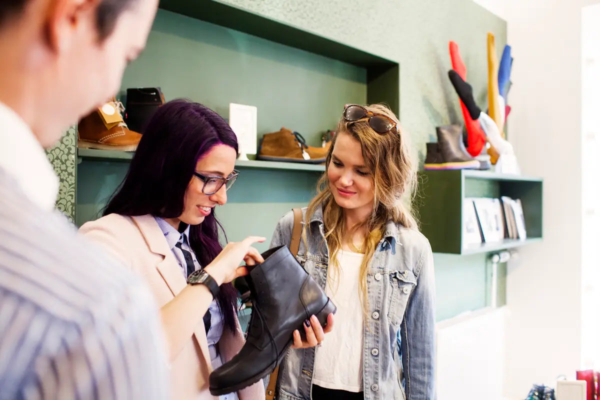 the legs of a woman who is choosing the right boot size next to other boots
