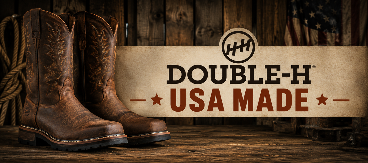A pair of brown western cowboy boots displayed against a rustic wooden backdrop with a large banner reading 'DOUBLE-H USA MADE' and a Double-H logo.