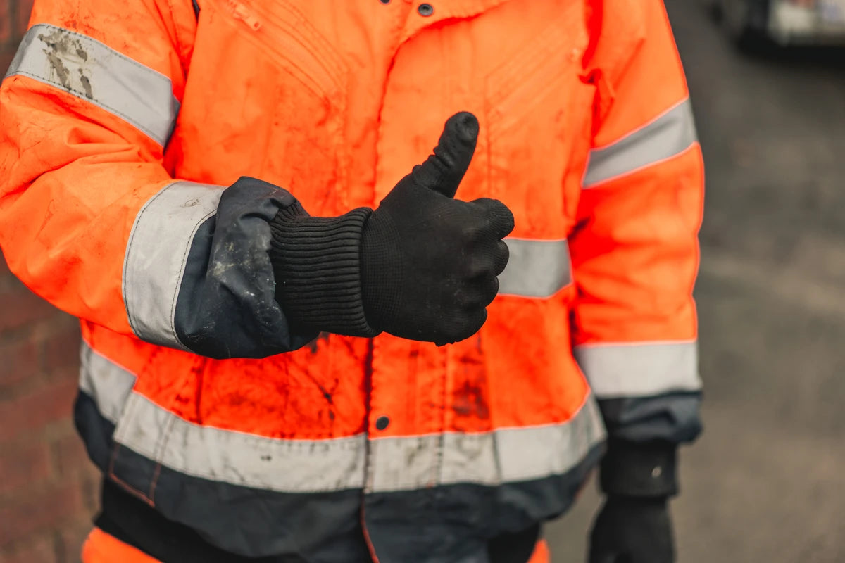 worker with black winter gloves showing thumb up