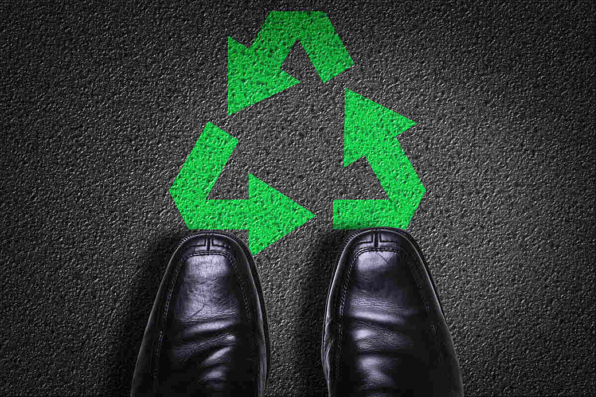 black shoes and green recycling logo 