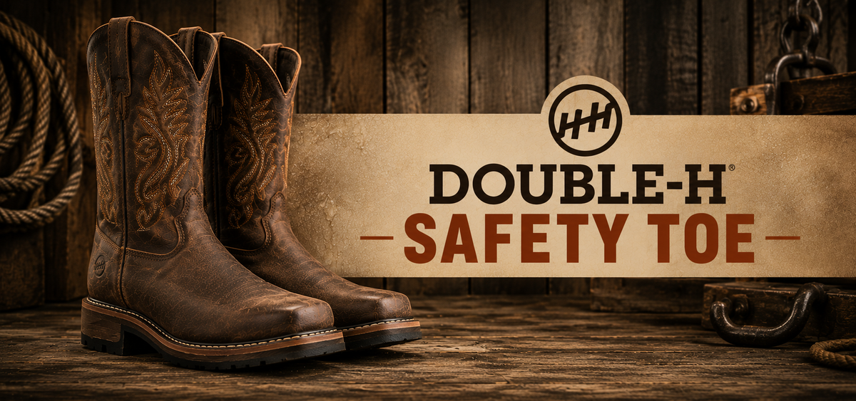 A pair of brown leather cowboy boots with decorative stitching, displayed on a rustic wooden surface next to a banner that reads 'DOUBLE-H SAFETY TOE' with the Double-H logo.