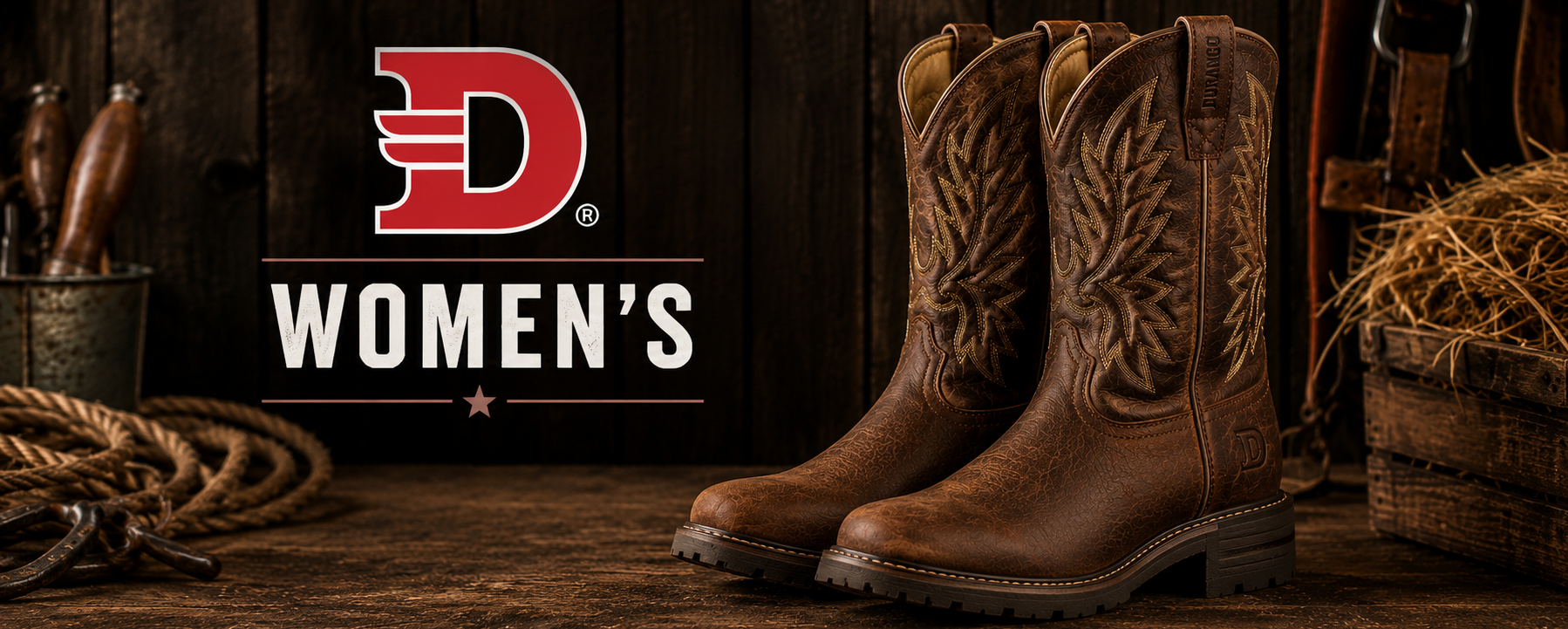 A pair of brown western-style women's leather boots with floral embroidery, displayed on a rustic wooden surface next to roping tools and hay, with the 'D Women's' logo on the left.